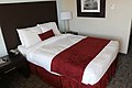 Modern queen size bed with a red valance, University of Massachusetts Amherst Hotel, Massachusetts