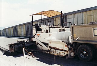 An asphalt paving machine being used to lay the "road base course" this is the layer of rocks under the asphalt.