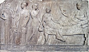 Relief en marbre, représentant Dionysos (à droite) et des acteurs tenant des masques (à gauche), voué au dieu après une représentation. Le Pirée, v. 400 av. J.-C. Musée national archéologique d'Athènes.