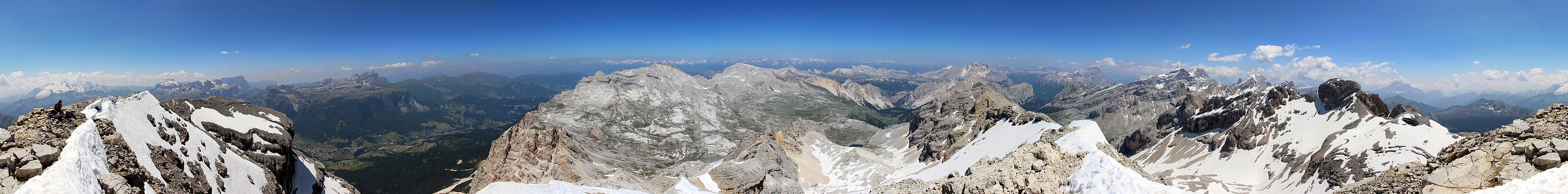 Panorama mit Blick auf die Hochfläche und die Berge der Fanesgruppe von der Lavarela. Der dunkle Fels rechts im Foto ist die Cima Cunturines